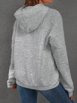 Person wearing a gray hoodie with text on the back against a gray background