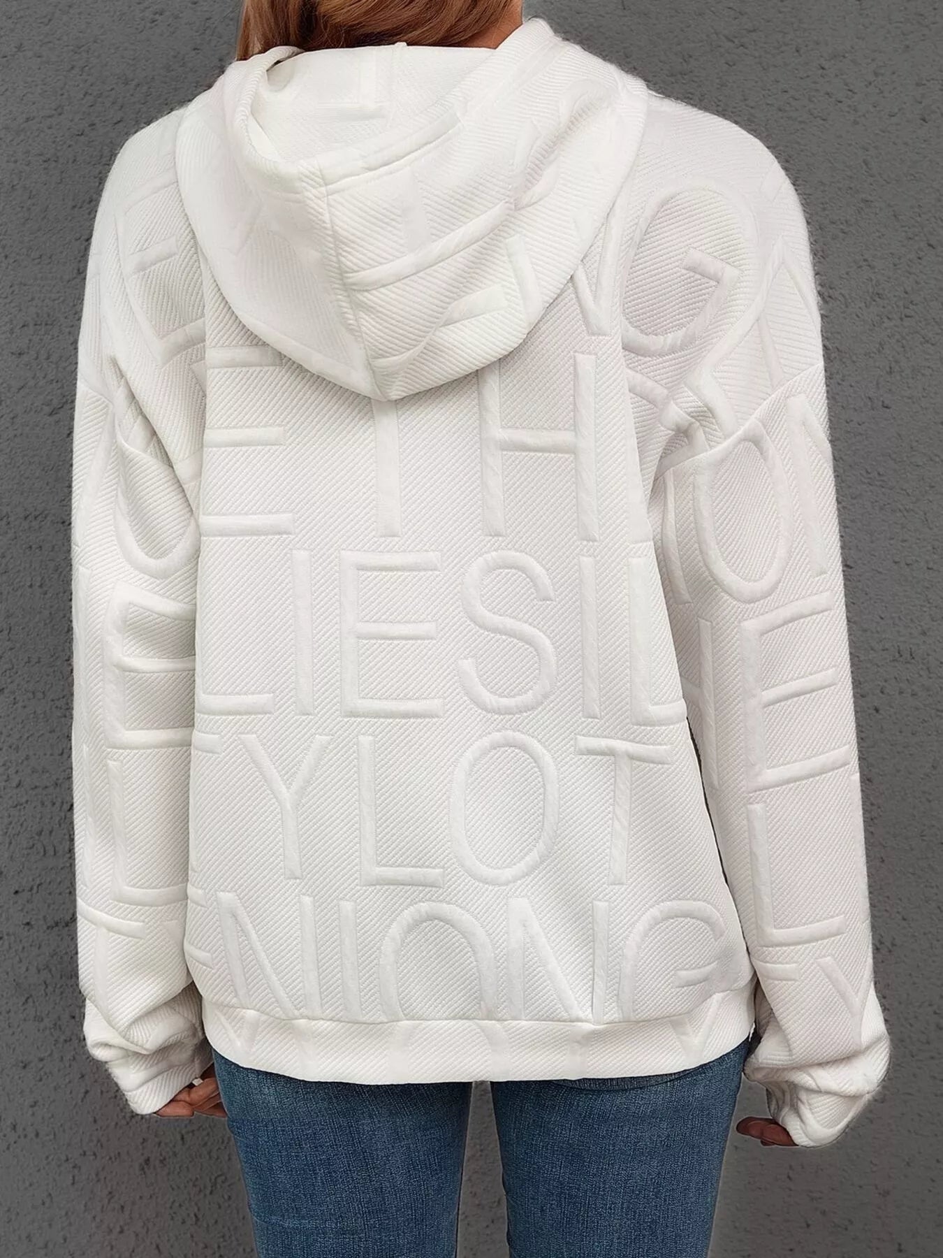 White textured hoodie with branding on the back against a gray background
