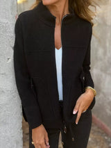 Women's black textured knit zip-up outerwear jacket with decorative button pockets, lightweight fall jacket available in sizes Small–5XL, styled over a white tank and black jeans.