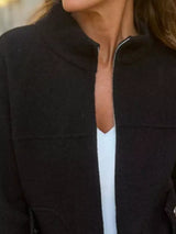 Women's black textured knit zip-up outerwear jacket with decorative button pockets, lightweight fall jacket available in sizes Small–5XL, styled over a white tank and black jeans.