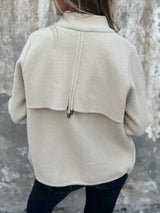 Women's white textured knit zip-up outerwear jacket with decorative button pockets, lightweight fall jacket available in sizes Small–5XL, styled over a white tank and black jeans.