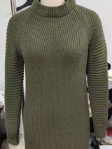 Woman wearing an army green turtleneck raglan sleeve sweater dress paired with white knee-high boots and a white crossbody bag for a chic fall outfit.
