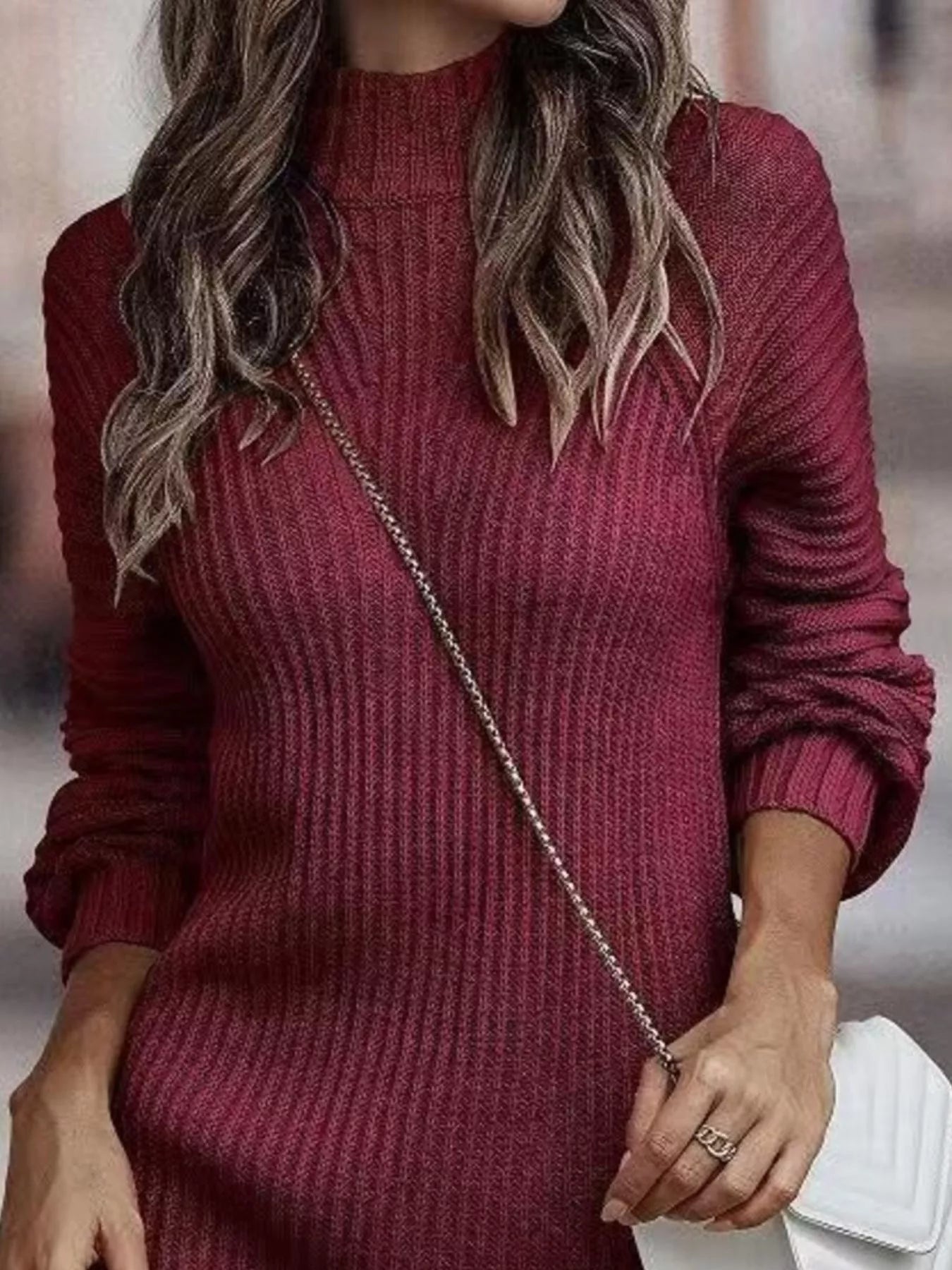 Woman wearing a burgundy turtleneck raglan sleeve sweater dress paired with white knee-high boots and a white crossbody bag for a chic fall outfit.