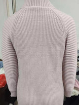 Woman wearing a dusty pink turtleneck raglan sleeve sweater dress paired with white knee-high boots and a white crossbody bag for a chic fall outfit.