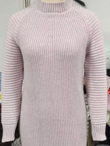 Woman wearing a dusty pink turtleneck raglan sleeve sweater dress paired with white knee-high boots and a white crossbody bag for a chic fall outfit.