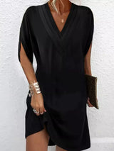 Black dress worn by a person against a white background