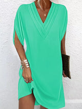 Green dress worn by a person on a white background