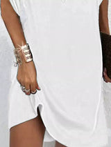 Person wearing a white dress with a focus on jewelry