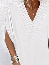 White top worn by a person with a plain background