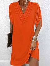 Orange dress worn by a person against a white background