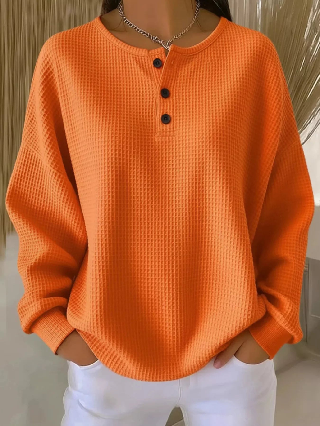 Orange textured sweater worn by a person with a neutral background