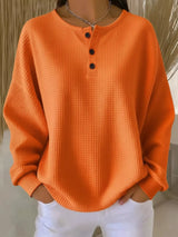 Orange textured sweater worn by a person with a neutral background