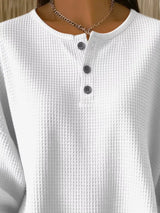 White textured shirt with buttons on a mannequin against a neutral background