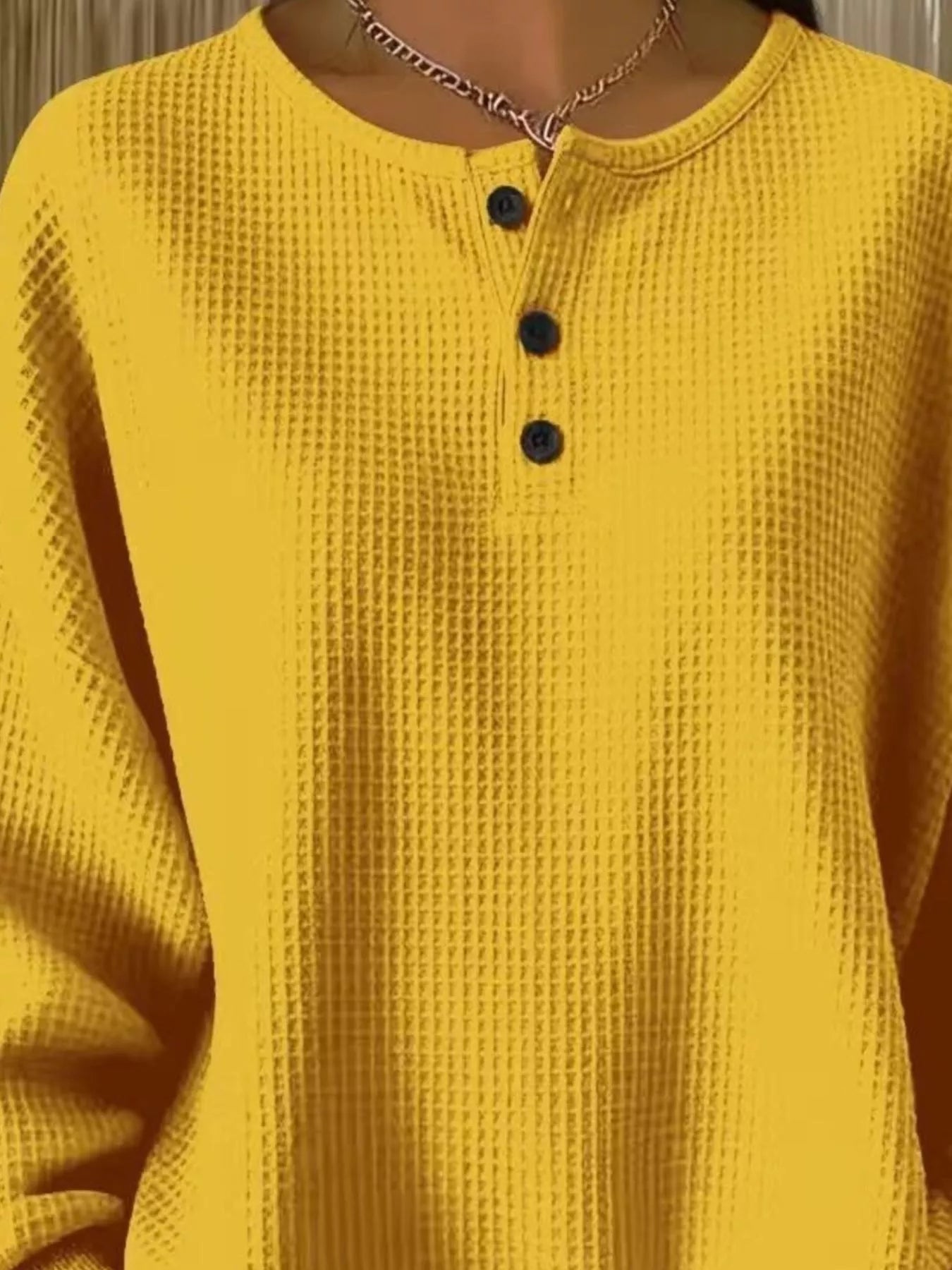 Yellow textured shirt with black buttons worn by a person