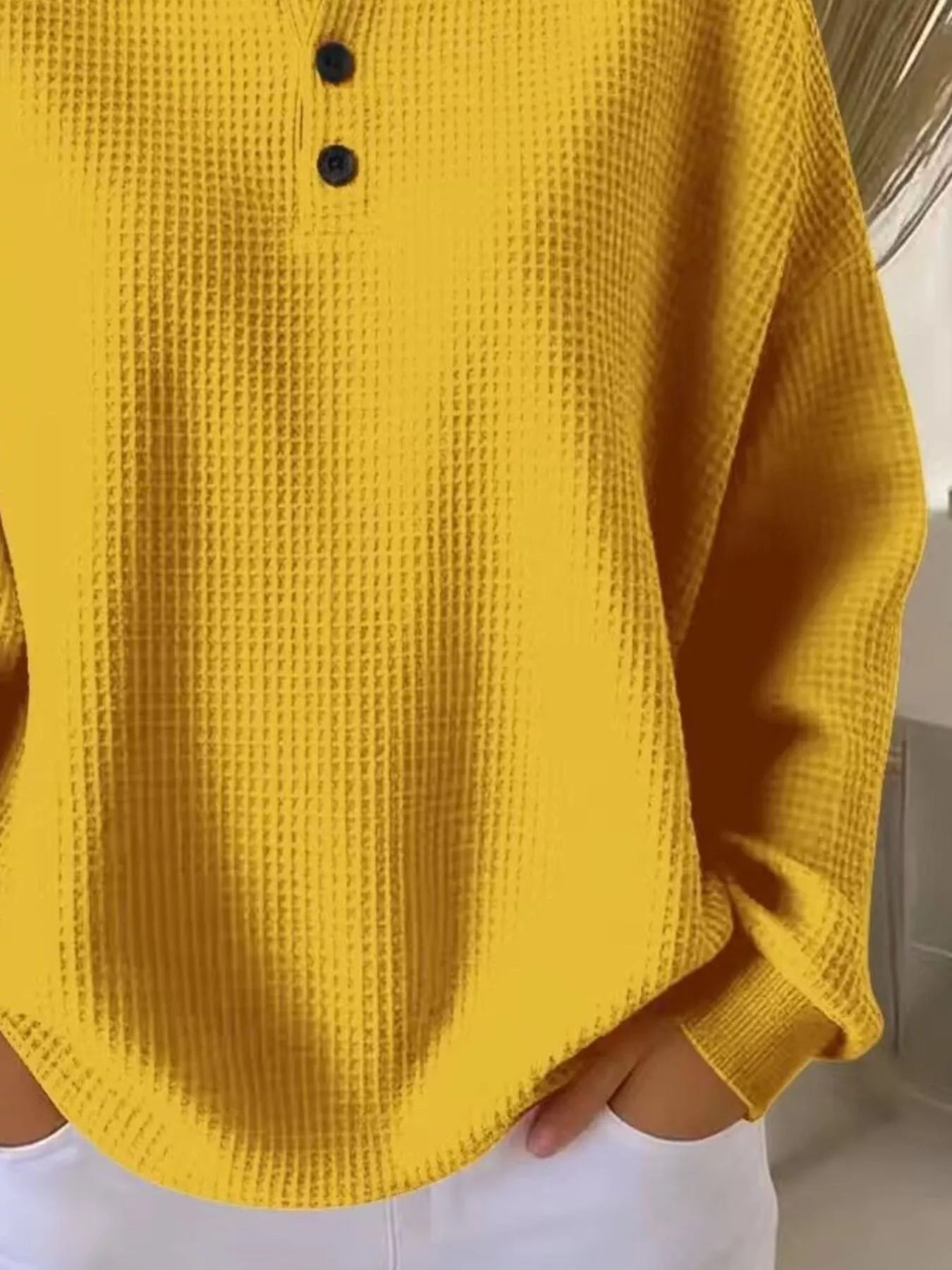 Yellow textured shirt worn by a person, with a neutral background