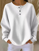 White textured long-sleeve top worn by a person against a neutral background
