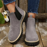 Gray suede round toe Chelsea ankle boots with black elastic side panels, mid-block heels and lug soles.