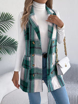 Women’s green plaid double-breasted long vest coat with pockets styled over a white turtleneck and jeans.
