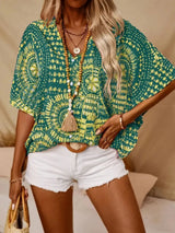 Green printed V-neck top with half sleeves and a relaxed boho-inspired fit paired with white shorts.