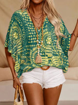 Green printed V-neck top with half sleeves and a relaxed boho-inspired fit paired with white shorts.