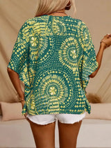 Green printed V-neck top with half sleeves and a relaxed boho-inspired fit paired with white shorts.