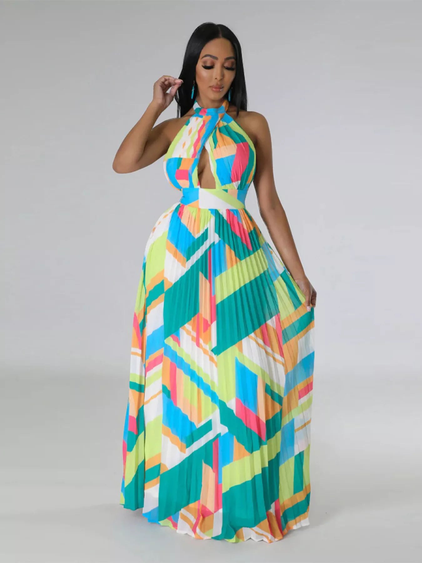 Woman wearing a colorful green geometric patterned dress on a gray background