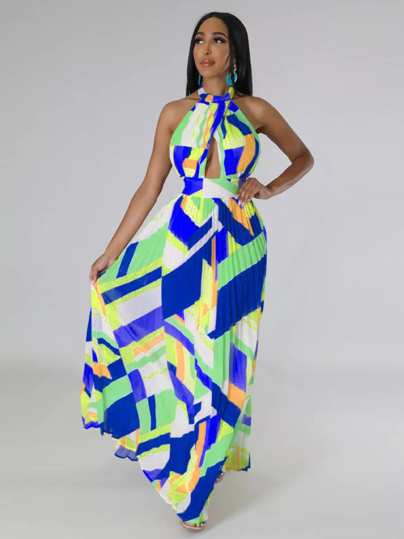 Woman wearing a colorful blue geometric patterned dress on a plain background