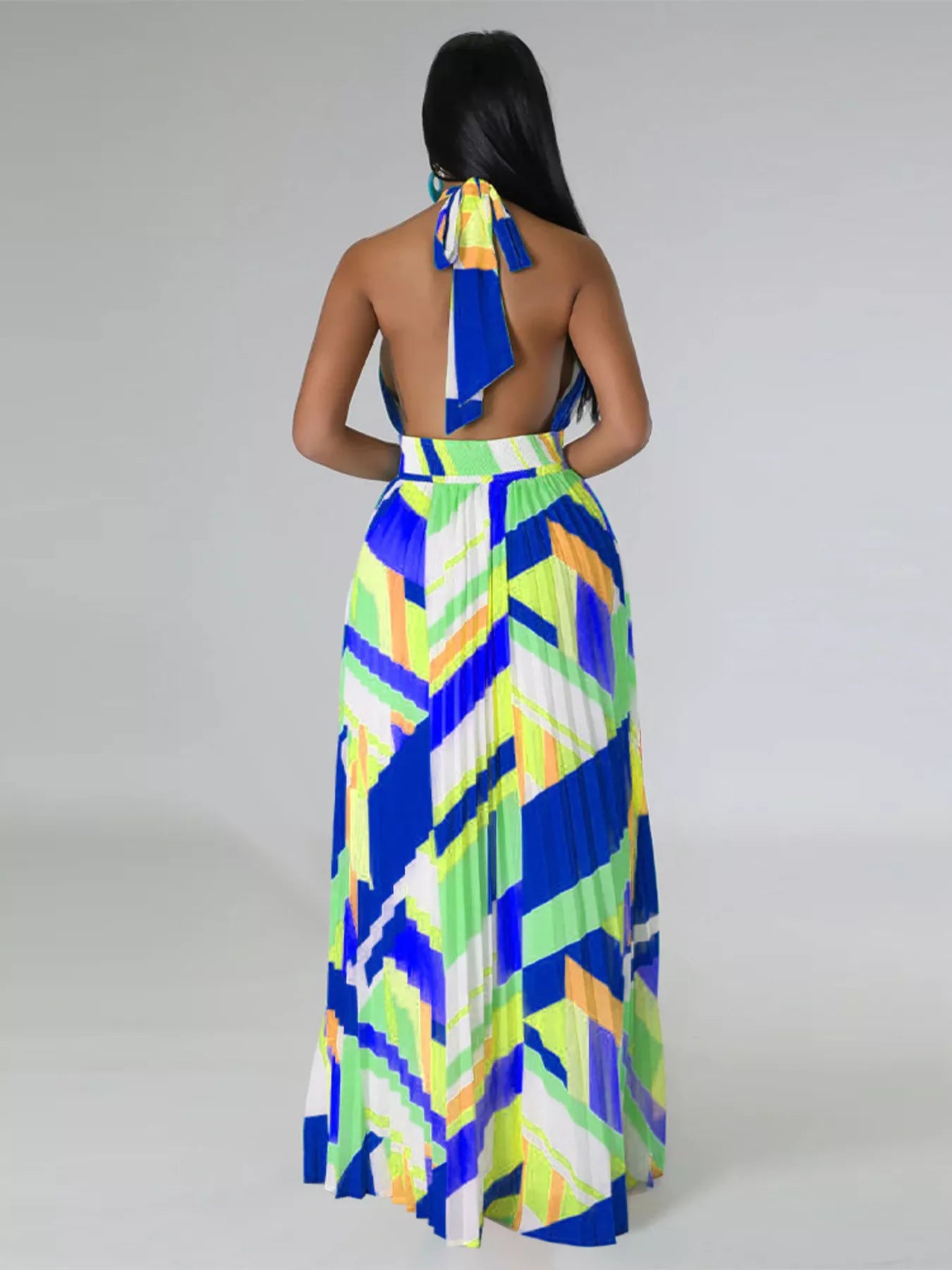 Woman wearing a colorful blue geometric patterned dress on a plain background