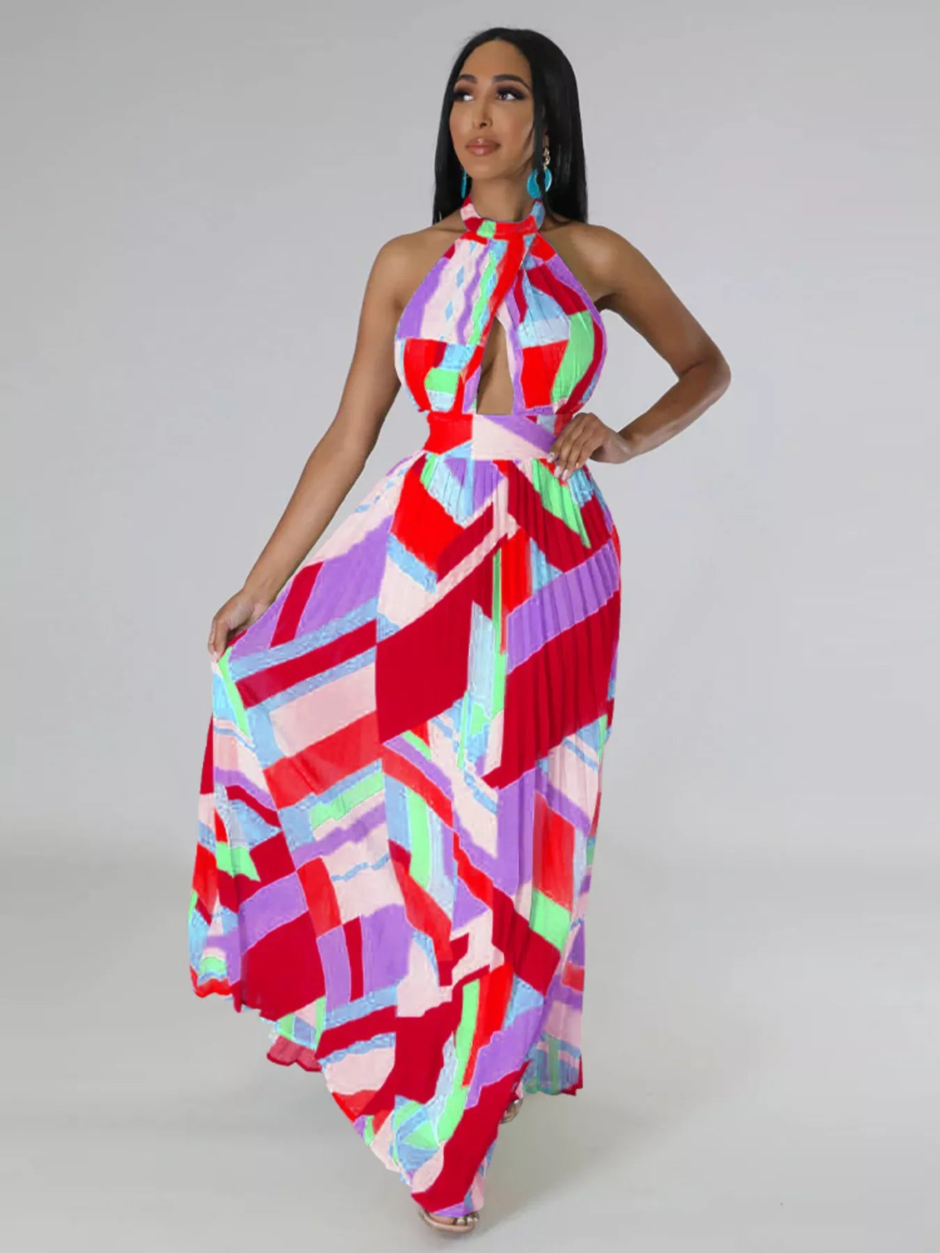 Woman wearing a colorful red geometric patterned dress on a plain background