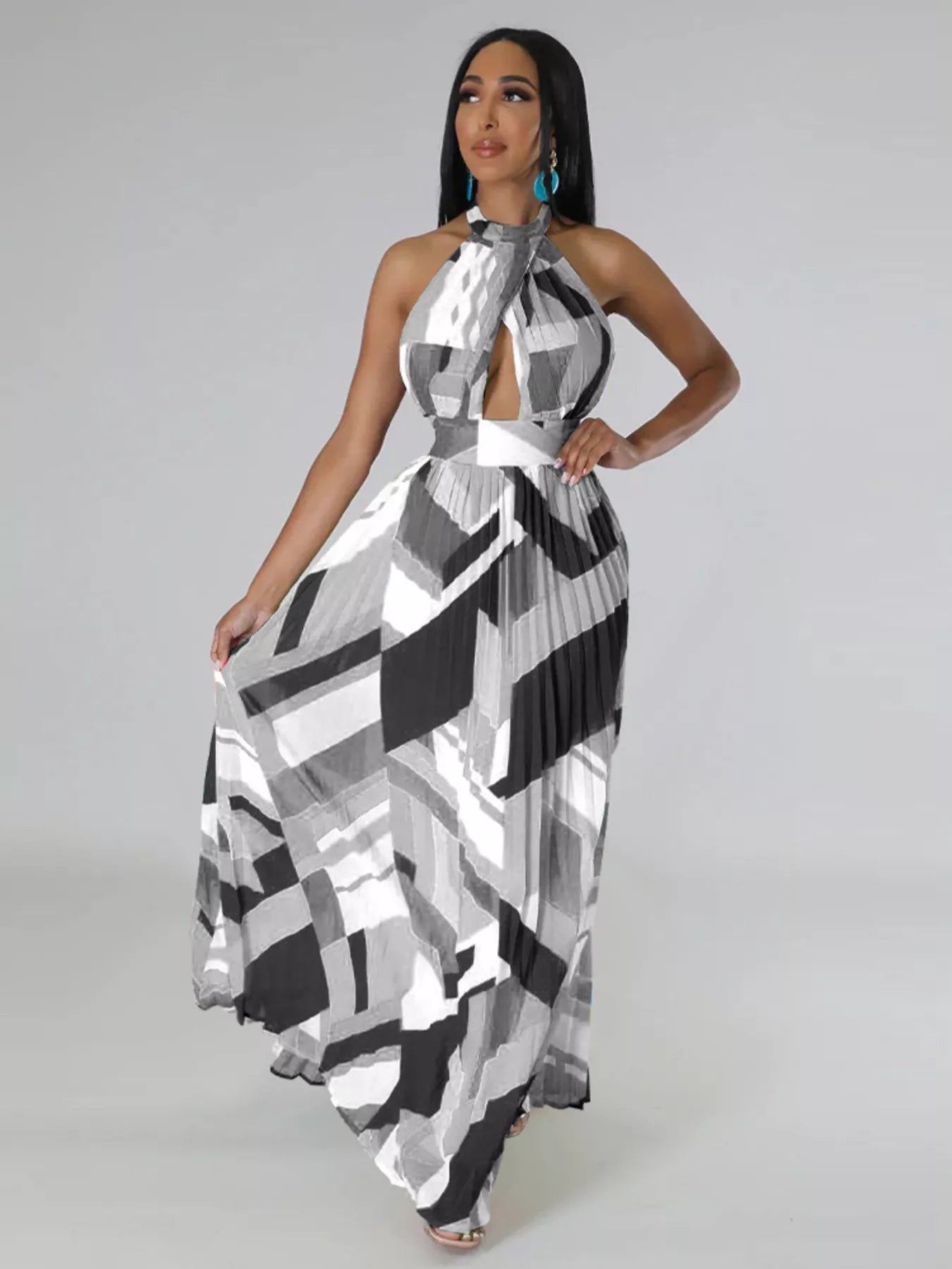 Woman wearing a black and white patterned halter neck dress on a gray background