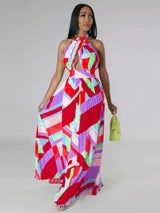 Woman wearing a colorful red geometric patterned dress on a plain background