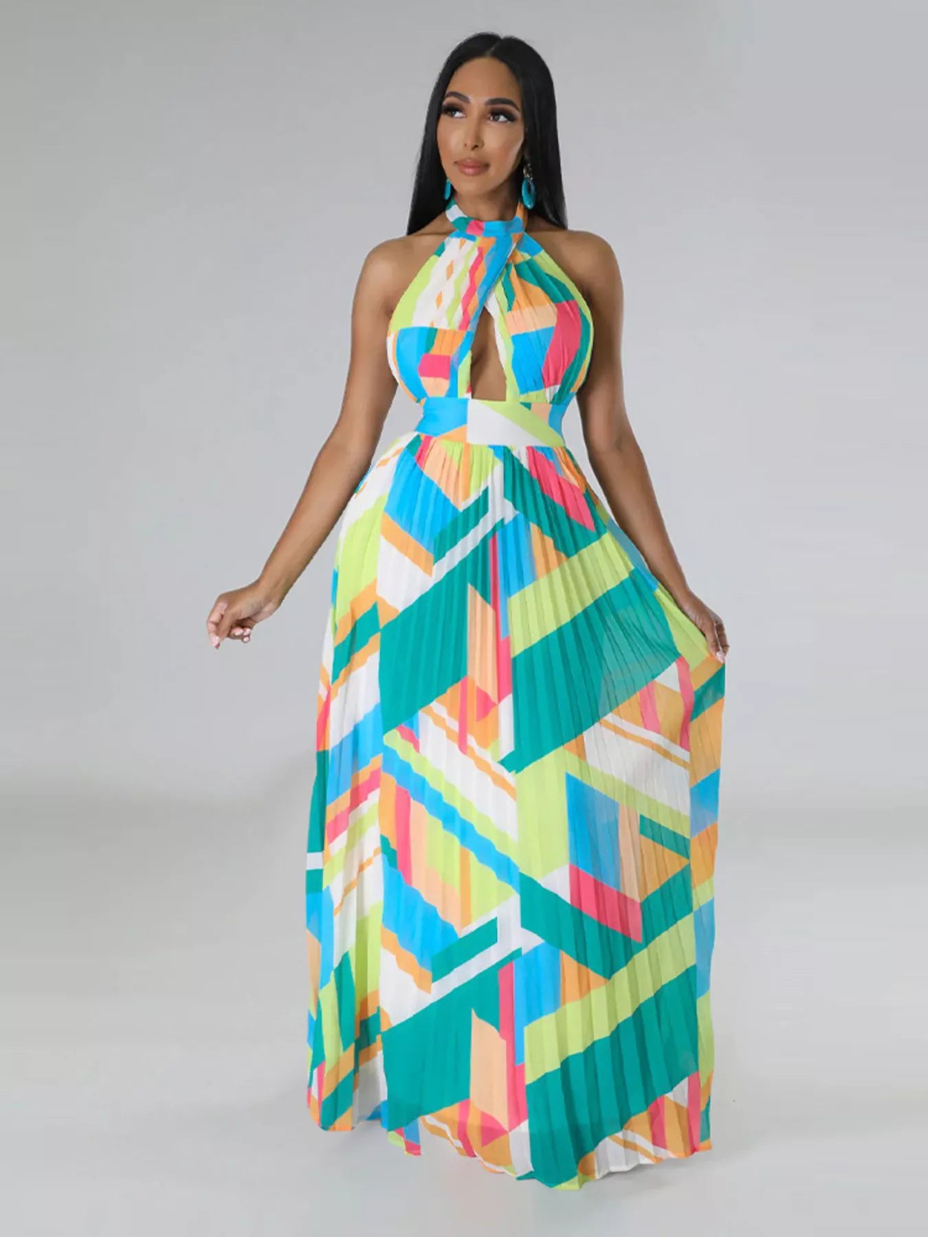 Woman wearing a colorful green geometric patterned dress on a gray background