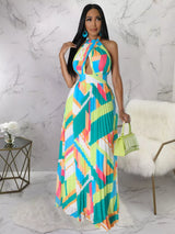 Woman wearing a colorful green geometric patterned dress in a marble room.