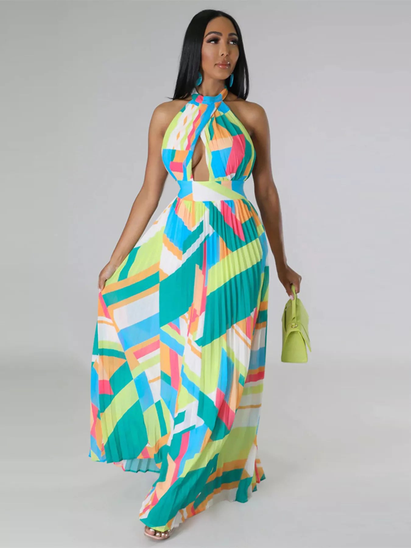 Woman wearing a colorful green geometric patterned dress on a plain background