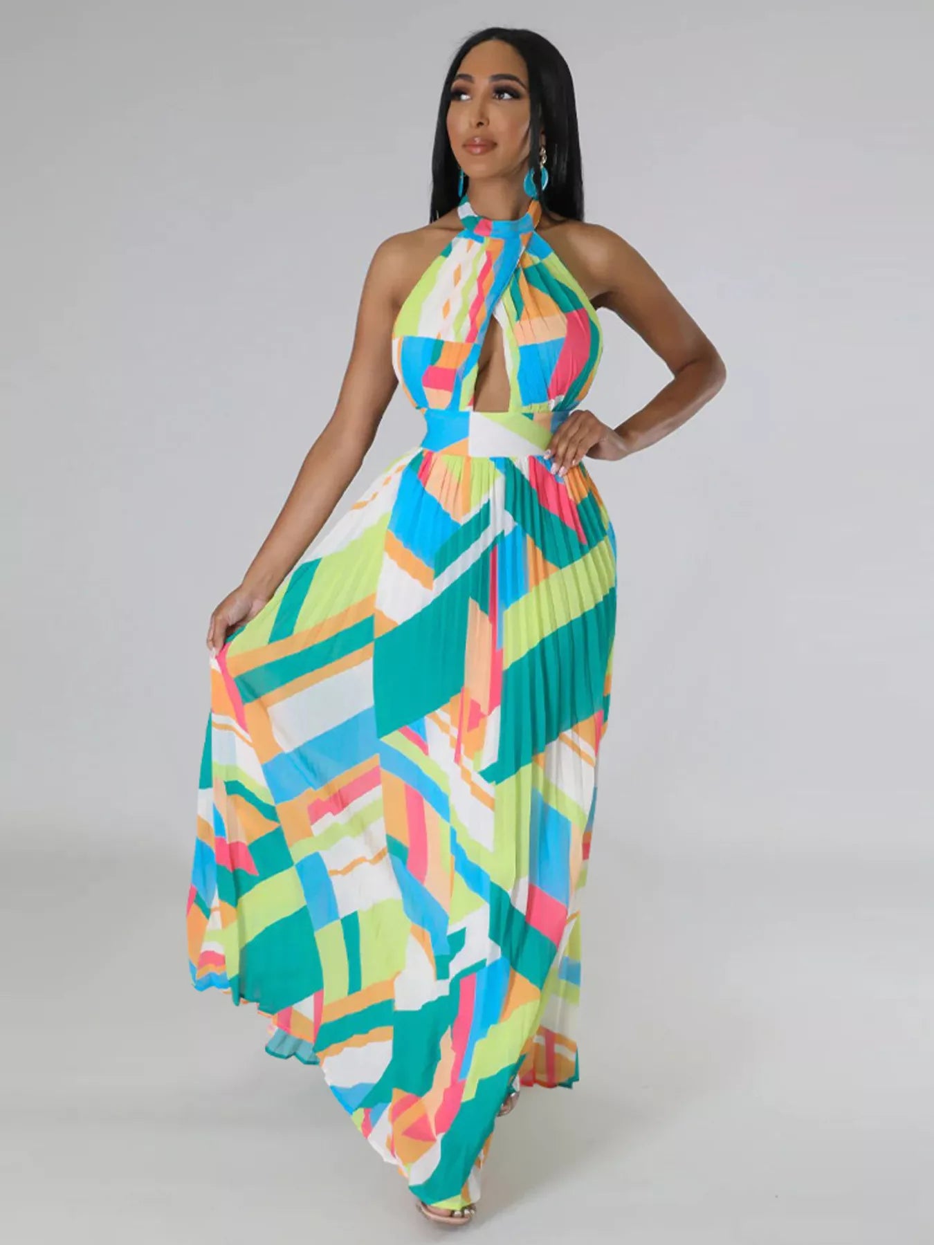 Woman wearing a colorful green geometric patterned dress on a plain background