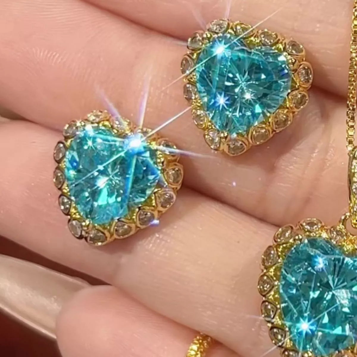 Heart-shaped aquamarine stud earrings with sparkling zircon halo accents in an elegant 18K gold-plated setting.
