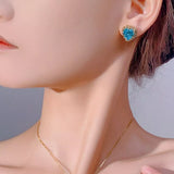 Heart-shaped aquamarine stud earrings with sparkling zircon halo accents in an elegant 18K gold-plated setting.