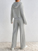 Woman wearing the Honey Drawstring Ribbed Hoodie and Straight Leg Pants Set in light gray with white sneakers, cozy ribbed two-piece lounge set from Chic Mystik Boutique.