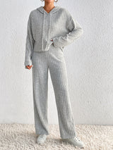 Woman wearing the Honey Drawstring Ribbed Hoodie and Straight Leg Pants Set in light gray with white sneakers, cozy ribbed two-piece lounge set from Chic Mystik Boutique.