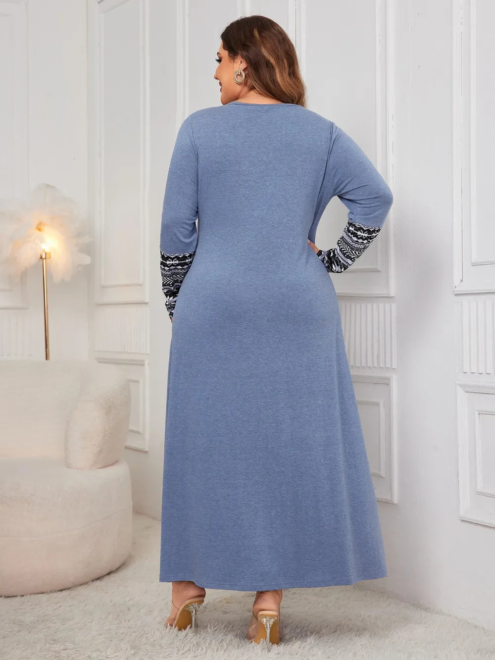 Woman wearing the Honey Plus Size Printed Long Sleeve Maxi Dress in blue with a Nordic-inspired print across the neckline and sleeves, cozy plus size fall maxi dress from Chic Mystik Boutique.