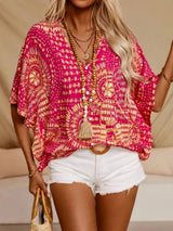 Hot pink printed V-neck top with half sleeves and a relaxed boho-inspired fit paired with white shorts.