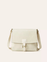 Ivory vintage-style crossbody bag featuring a flap closure, decorative buckle detail, and adjustable shoulder strap.