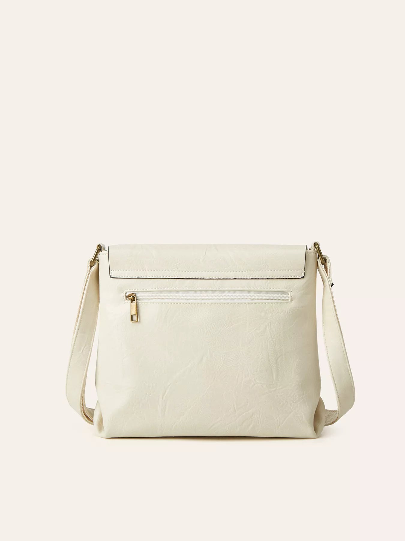Ivory vintage-style crossbody bag featuring a flap closure, decorative buckle detail, and adjustable shoulder strap.