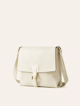 Ivory vintage-style crossbody bag featuring a flap closure, decorative buckle detail, and adjustable shoulder strap.