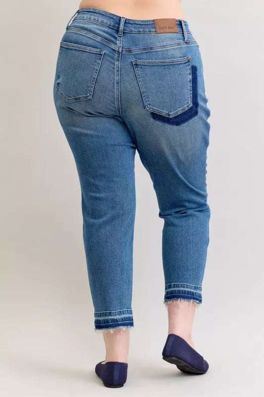Judy Blue Full-Size Mid-Rise BF Patch & Repair Destroy Release Hem Jeans in medium wash featuring distressed detailing, boyfriend fit, raw release hem, and slightly stretchy denim for casual everyday style.