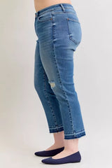 Judy Blue Full-Size Mid-Rise BF Patch & Repair Destroy Release Hem Jeans in medium wash featuring distressed detailing, boyfriend fit, raw release hem, and slightly stretchy denim for casual everyday style.