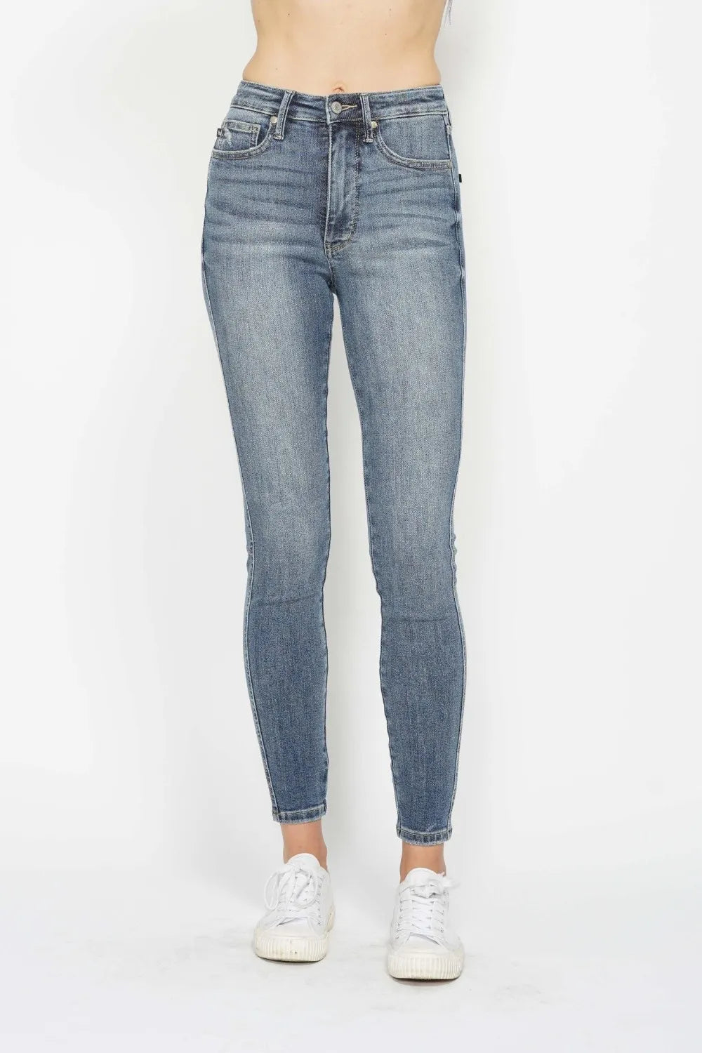 Woman wearing Judy Blue high-rise tummy control contrast wash skinny jeans with a flattering skinny-leg fit and light medium wash denim.