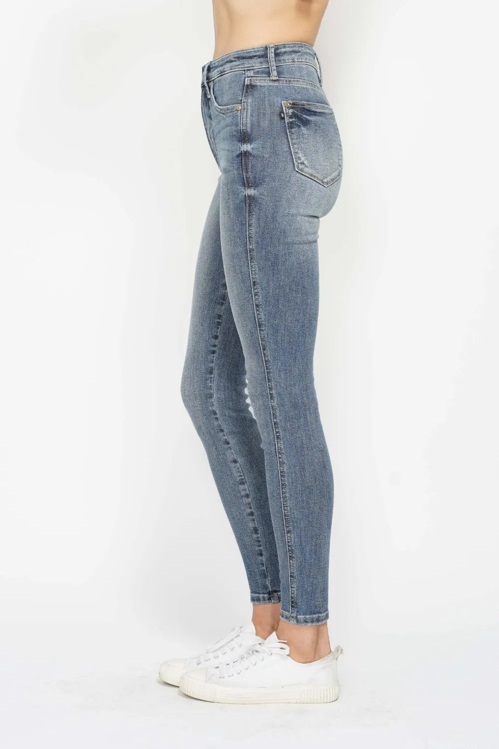 Woman wearing Judy Blue high-rise tummy control contrast wash skinny jeans with a flattering skinny-leg fit and light medium wash denim.