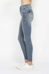 Woman wearing Judy Blue high-rise tummy control contrast wash skinny jeans with a flattering skinny-leg fit and light medium wash denim.