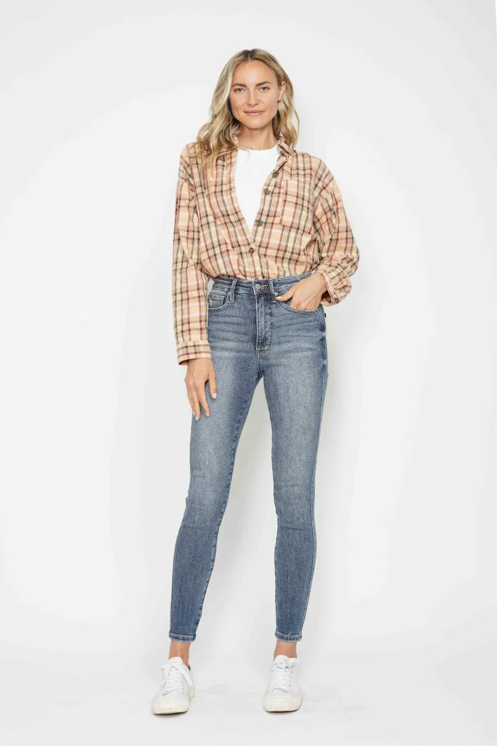 Woman wearing Judy Blue high-rise tummy control contrast wash skinny jeans with a flattering skinny-leg fit and light medium wash denim.
